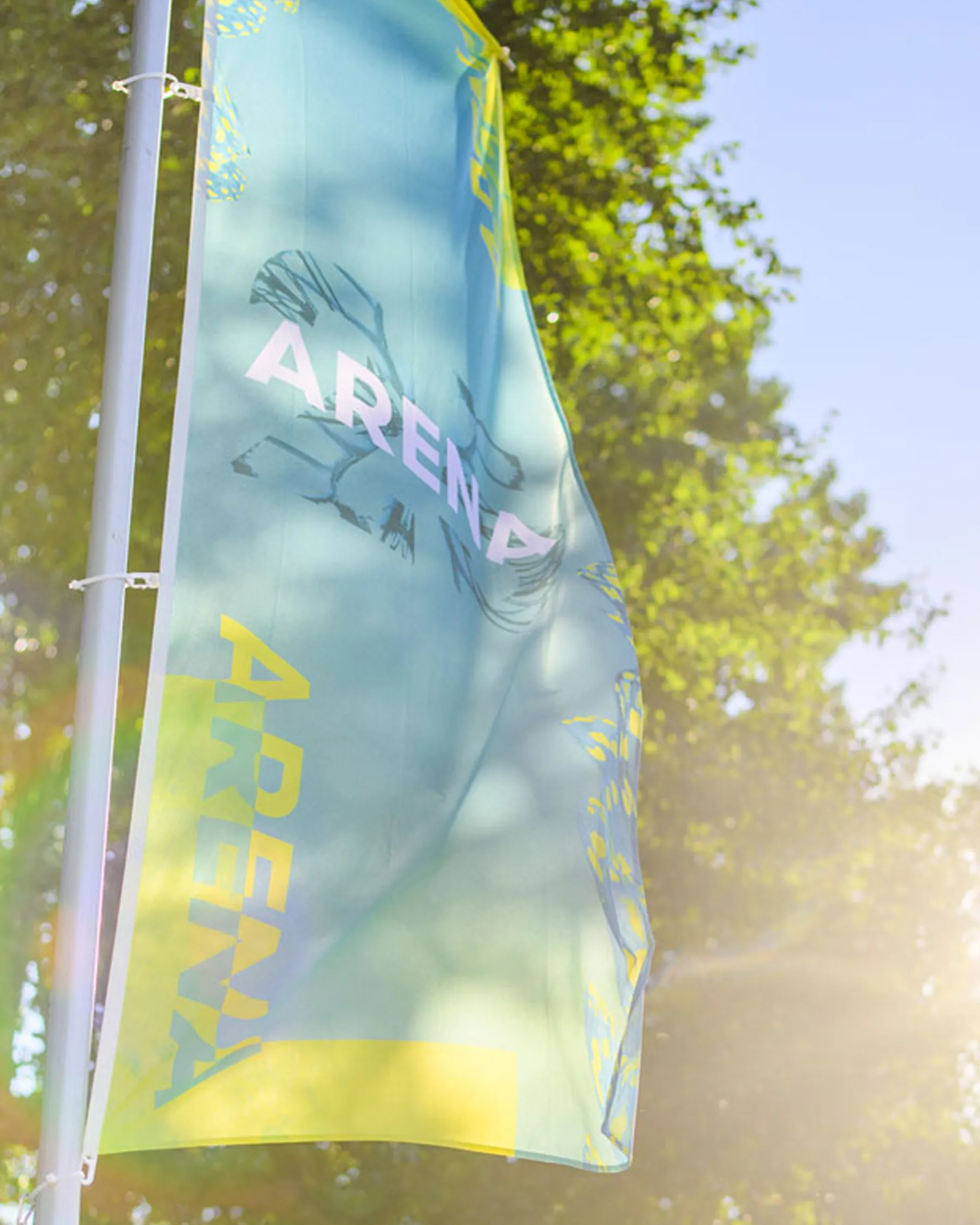 Loveland anniversary flag flying against the trees on the festival terrain