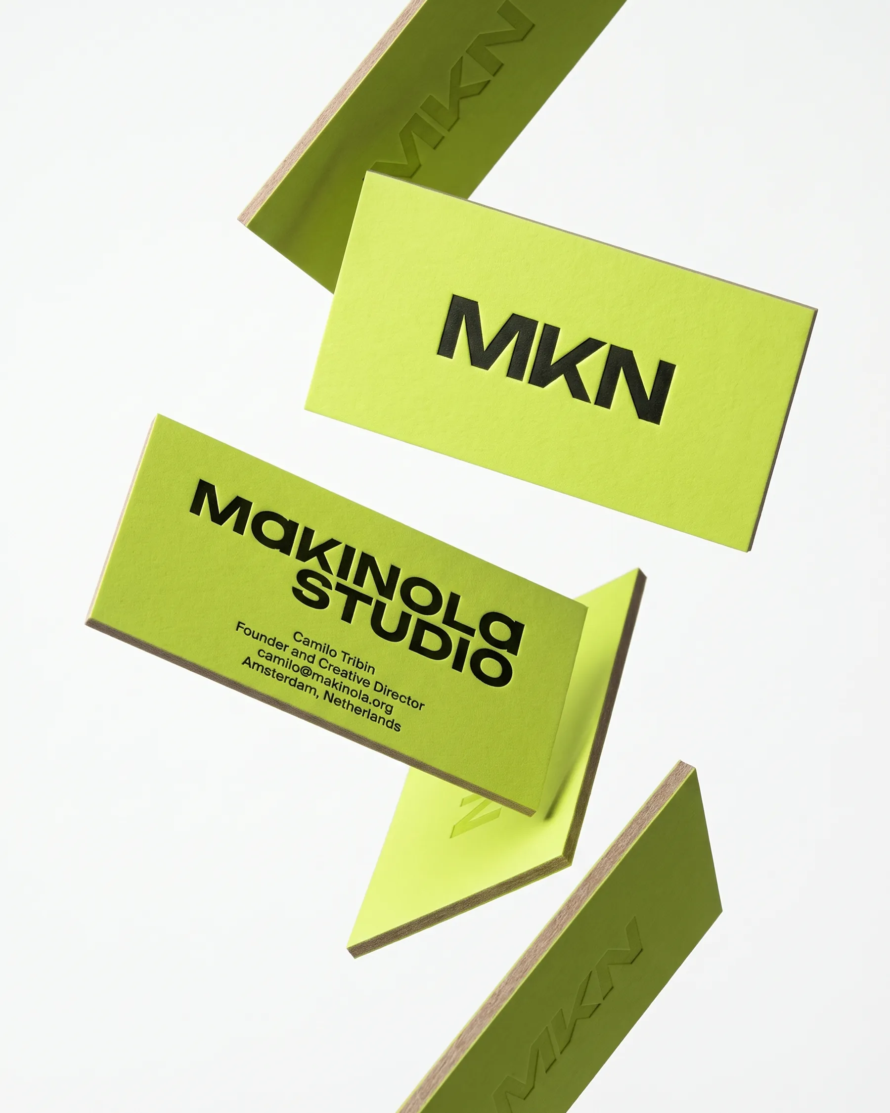 Lime MKN business cards floating against a white studio background